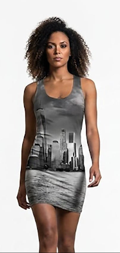 A woman modeling a sleeveless gray mini dress with a black and white city skyline graphic print, standing against a solid white studio background.